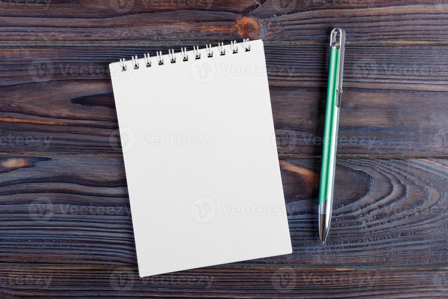 A notebook and pen on wood background photo