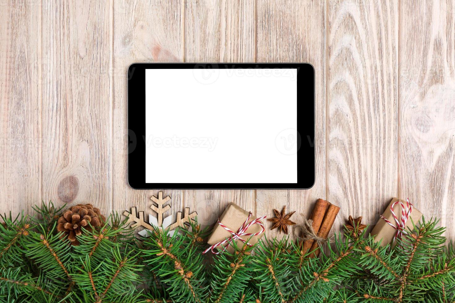 Digital tablet mock up with rustic Christmas wood background decorations for app presentation. top view with copy space photo