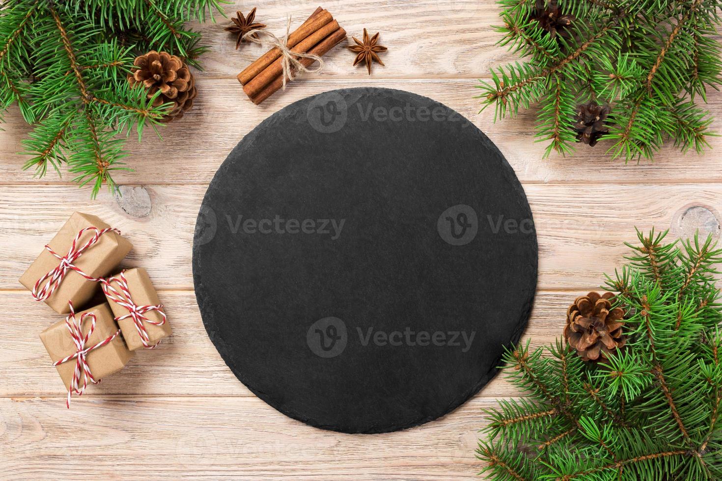 Empty Slate plate on table with christmas decoration. black slate stone on wooden background. copy space. New Year concept photo