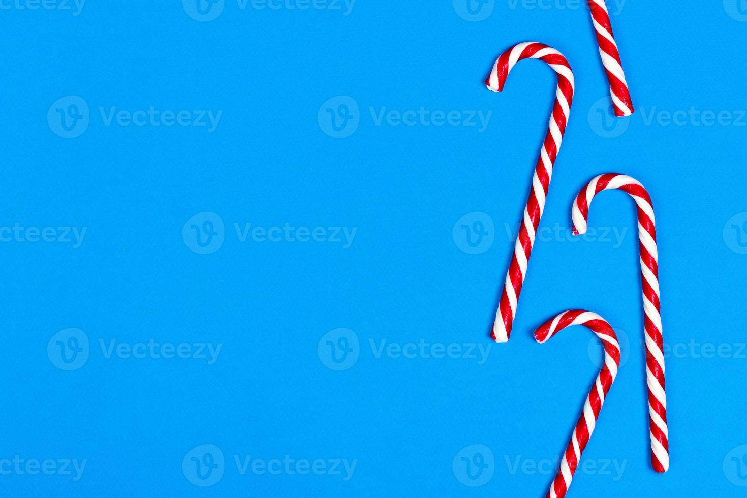 Christmas candy can in row on blue background. Flat lay. Copy space photo