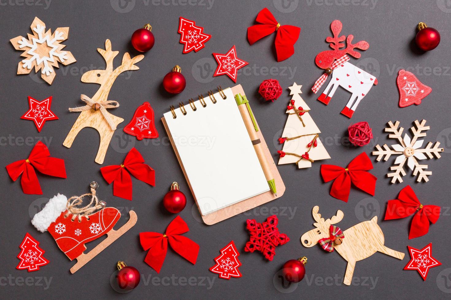 Christmas black background with holiday toys and decorations. Top view of notebook. Happy New Year concept photo