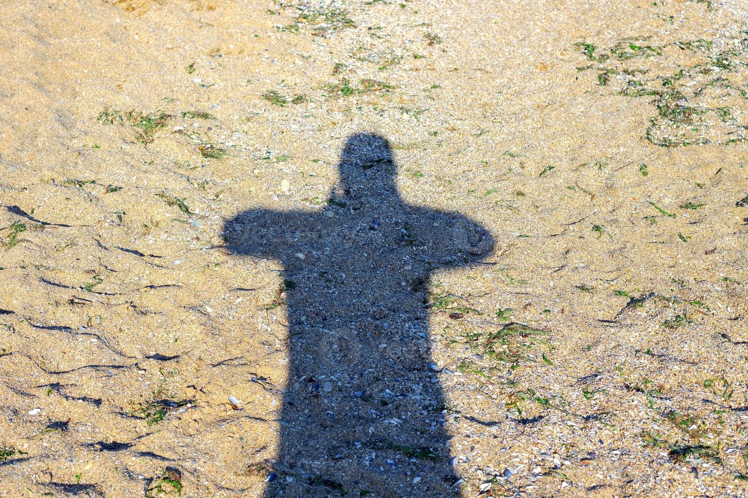 Shadow of man traveler with backpack take photo on sand beach at sunset time, Travel