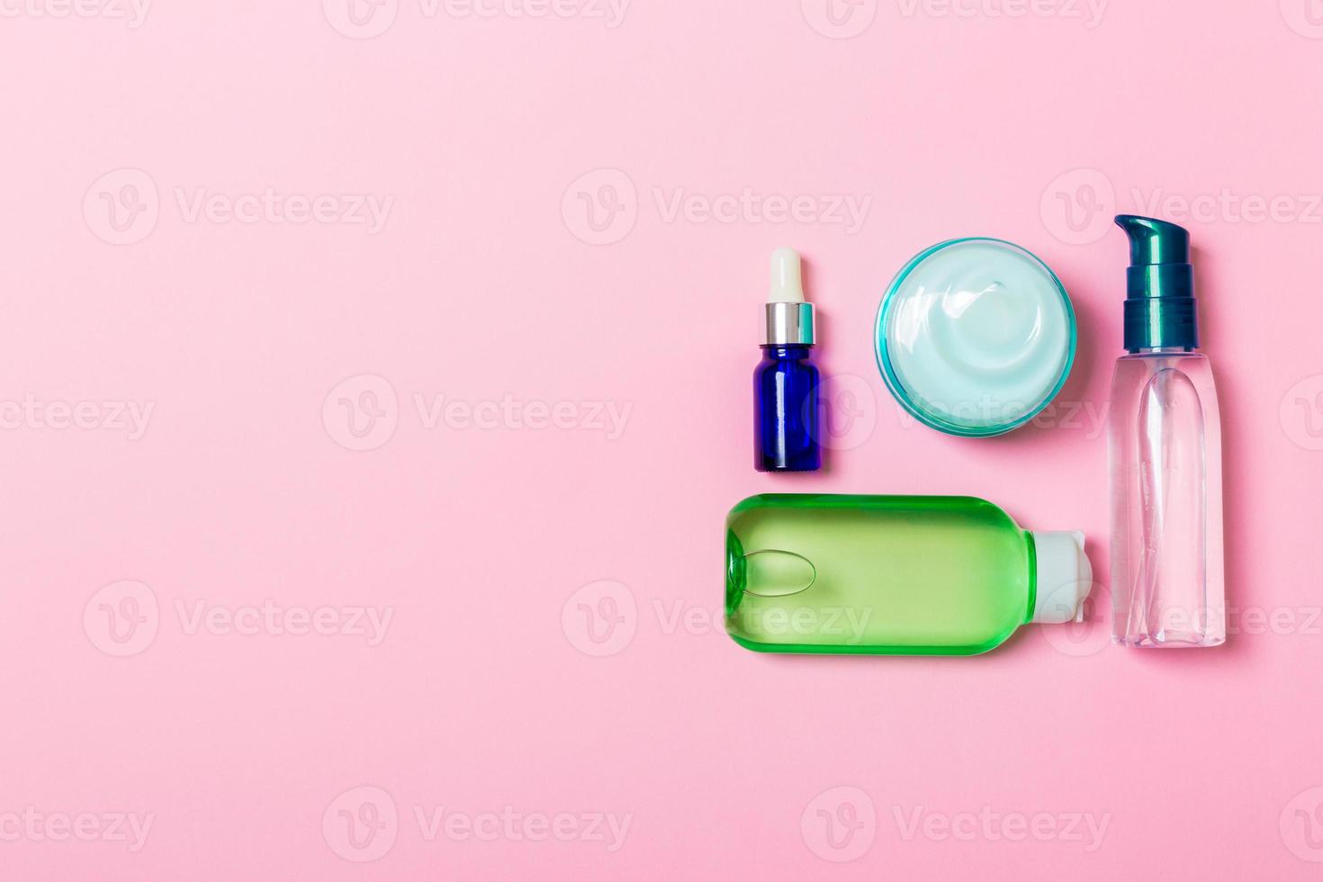 maqueta de marca de spa de cosméticos, vista superior con espacio de copia. conjunto de tubos y tarros de crema sobre fondo rosa foto