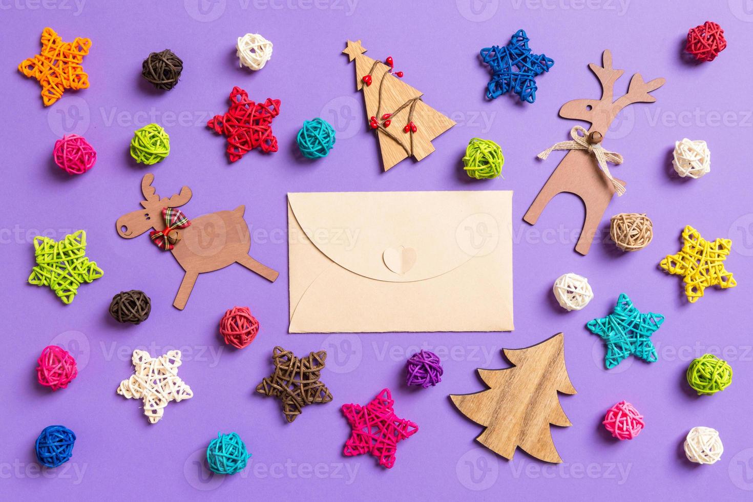 Top view of craft envelope. New Year decorations on purple background. Festive stars and balls. Merry Christmas concept photo