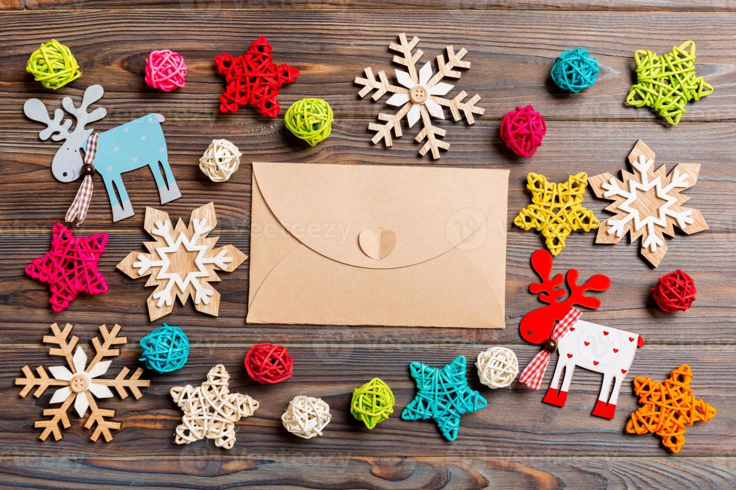 Top view of envelope on festive wooden background. Christmas toys and decorations. New Year time concept photo