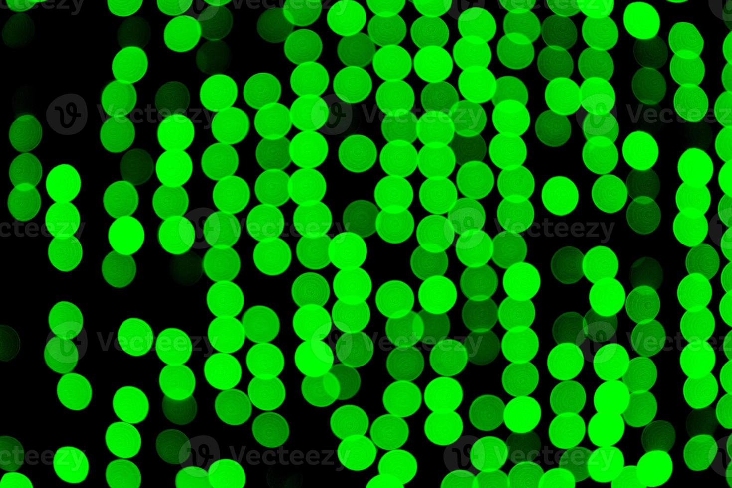 Unfocused abstract green bokeh on black background. defocused and blurred many round light photo