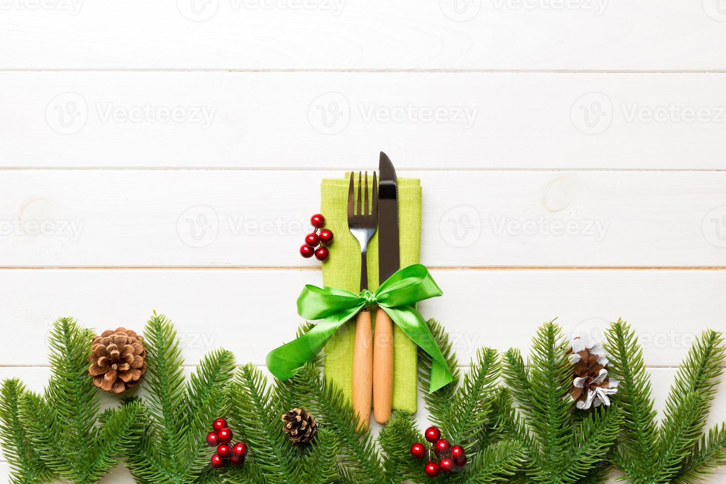 Top view of festive cutlery on new year wooden background. Christmas decorations with empty space for your design. Holiday dinner concept photo