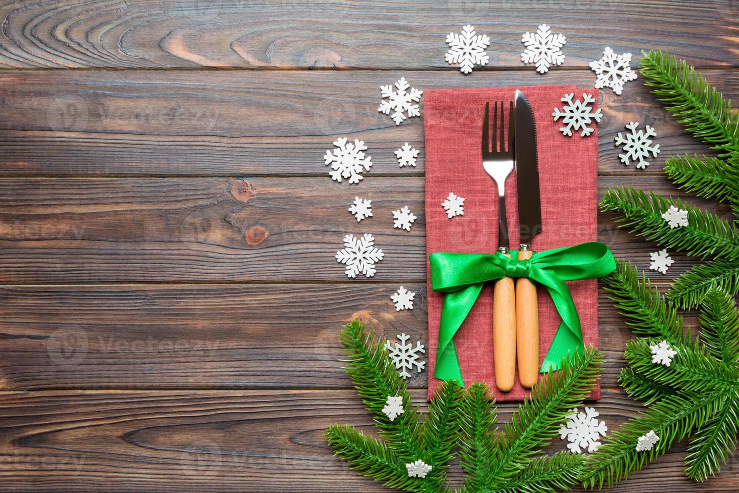Top view of festive cutlery on new year wooden background. Christmas decorations with empty space for your design. Holiday dinner concept photo