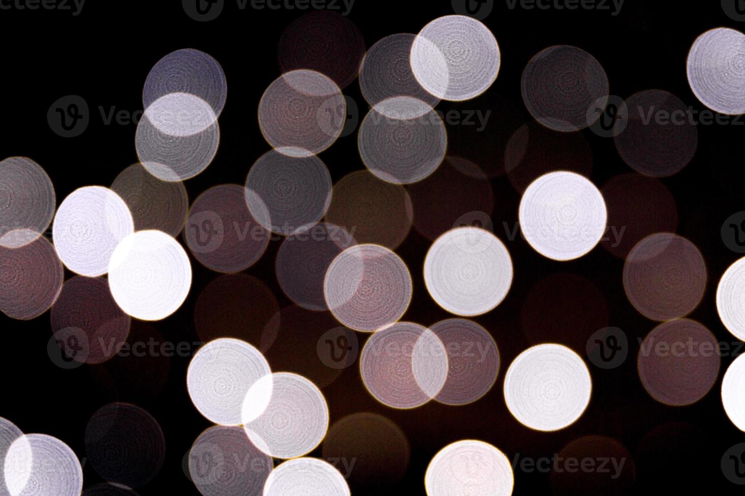 Unfocused abstract white bokeh on black background. defocused and blurred many round light photo
