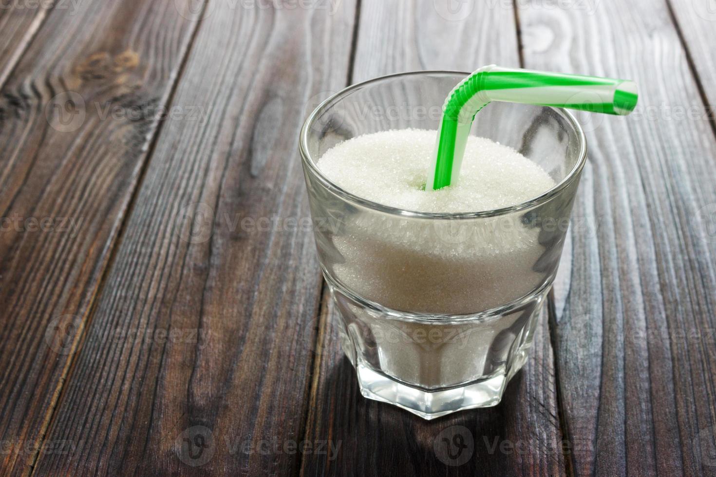 cubos de azúcar blanca en un vaso con túbulo foto