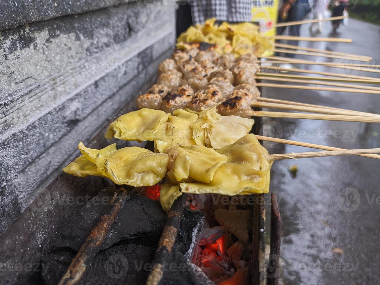 albóndigas a la parrilla. comida local tradicional de la calle en indonesia donde el proceso de fabricación se asa a la parrilla con carbón caliente foto