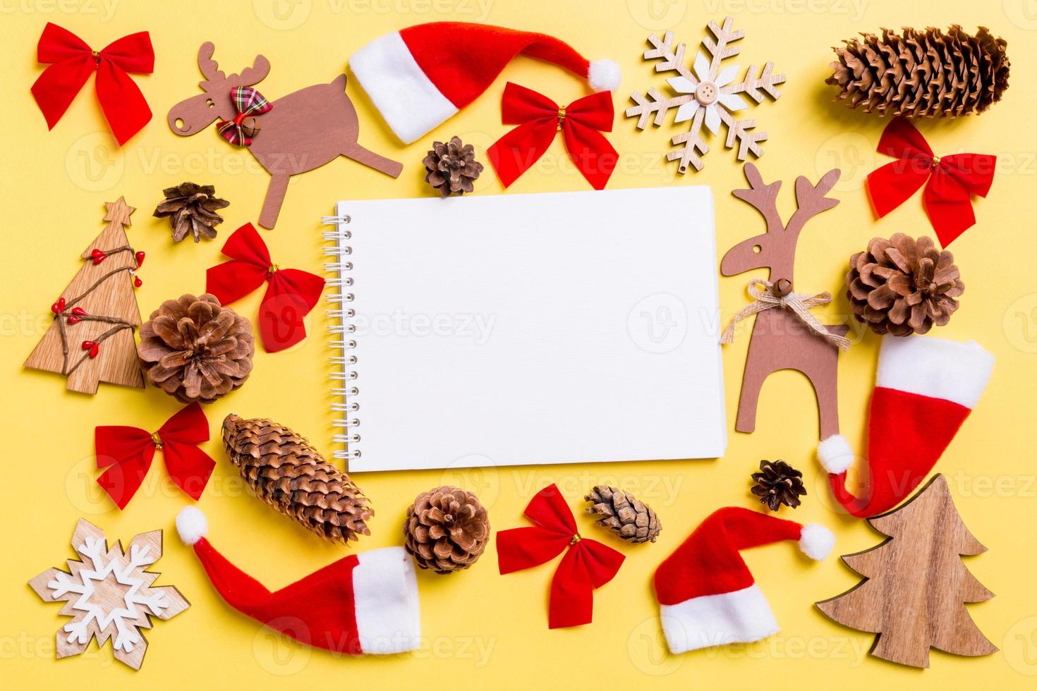 Christmas yellow background with holiday toys and decorations. Top view of notebook. Happy New Year concept photo