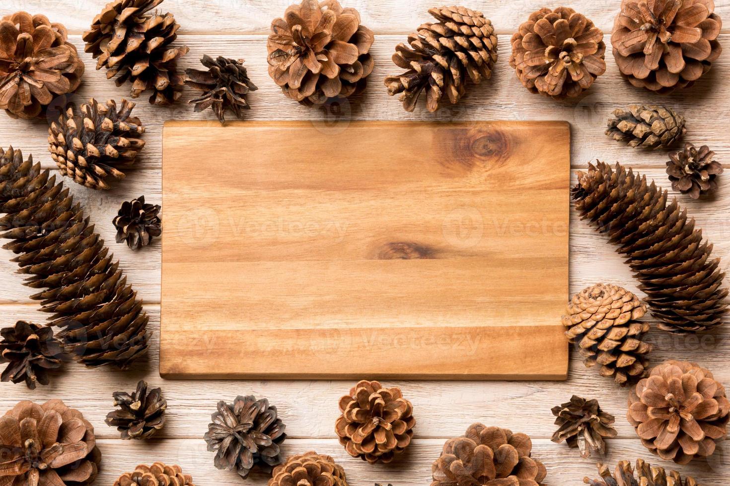 Top view of festive plate with pine cones on wooden background. New Year dinner concept photo