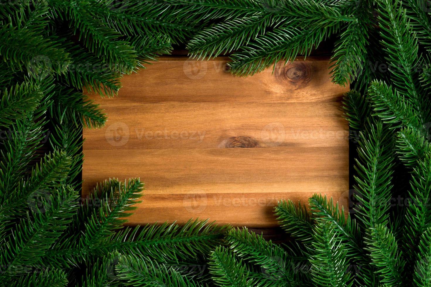Top view of wooden plate decorated with fir tree branches. New Year dinner concept with empty space for your design photo