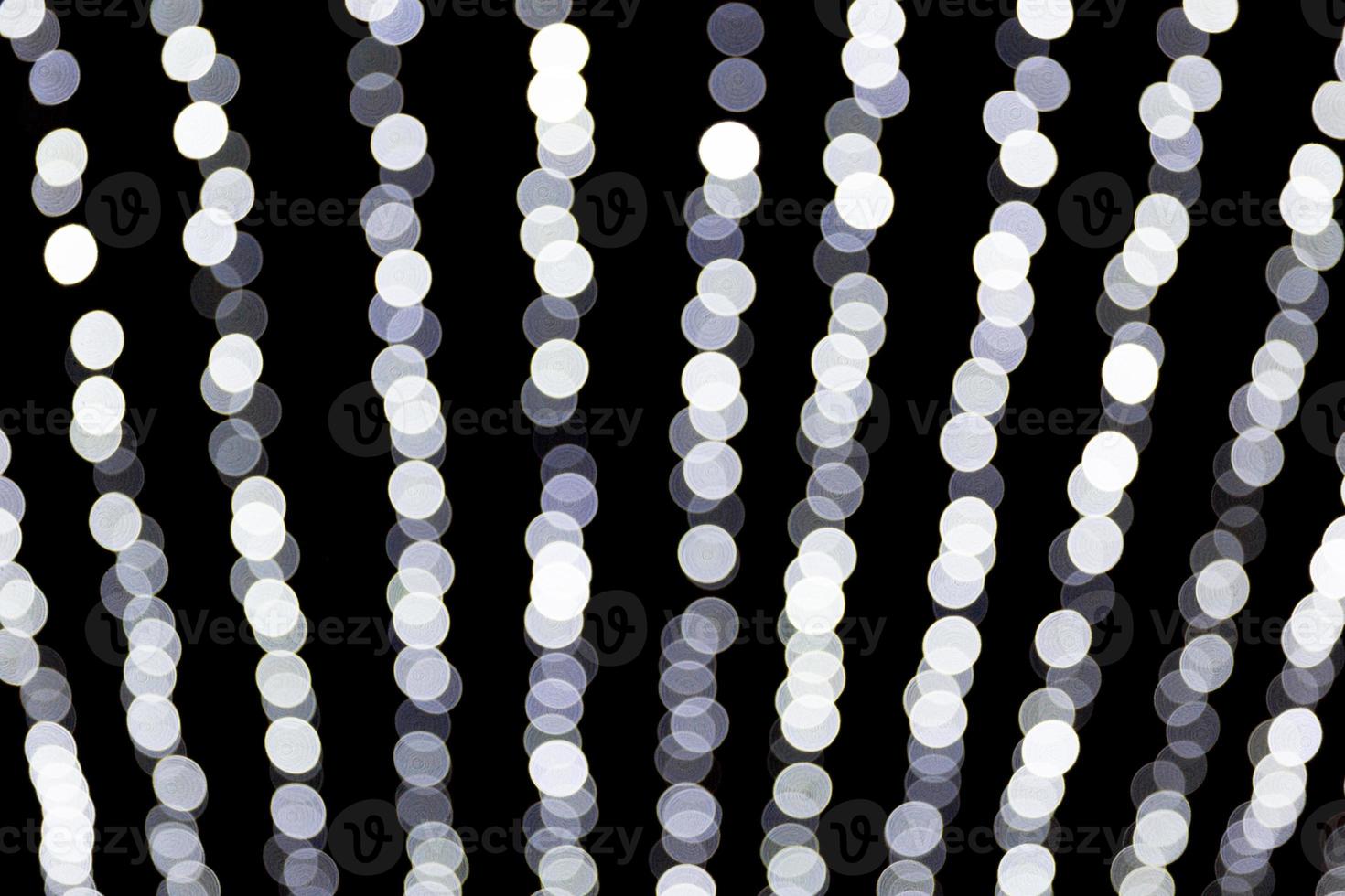 Abstract bokeh of white lights on black background. defocused and blurred many round light photo