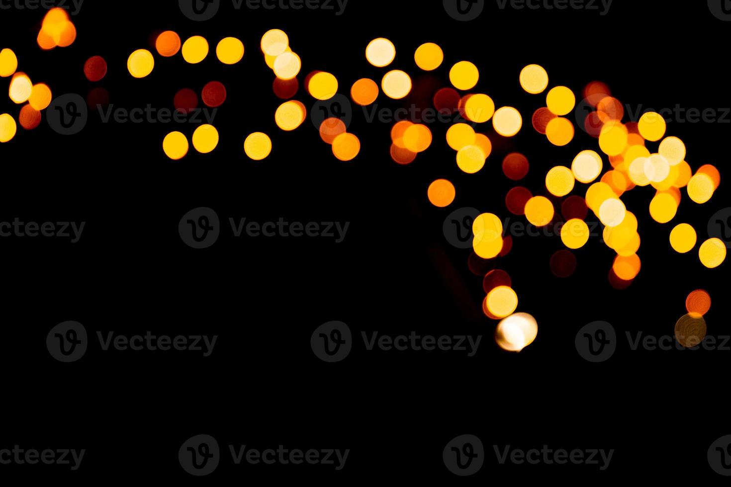 Unfocused abstract orange bokeh on black background. defocused and blurred many round light photo