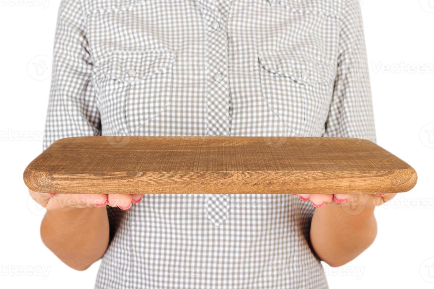 girl in the plaid shirt is holding an empty wooden rectangular plate in front of her. woman hand hold empty dish for you desing. perspective view, isolated on white background photo