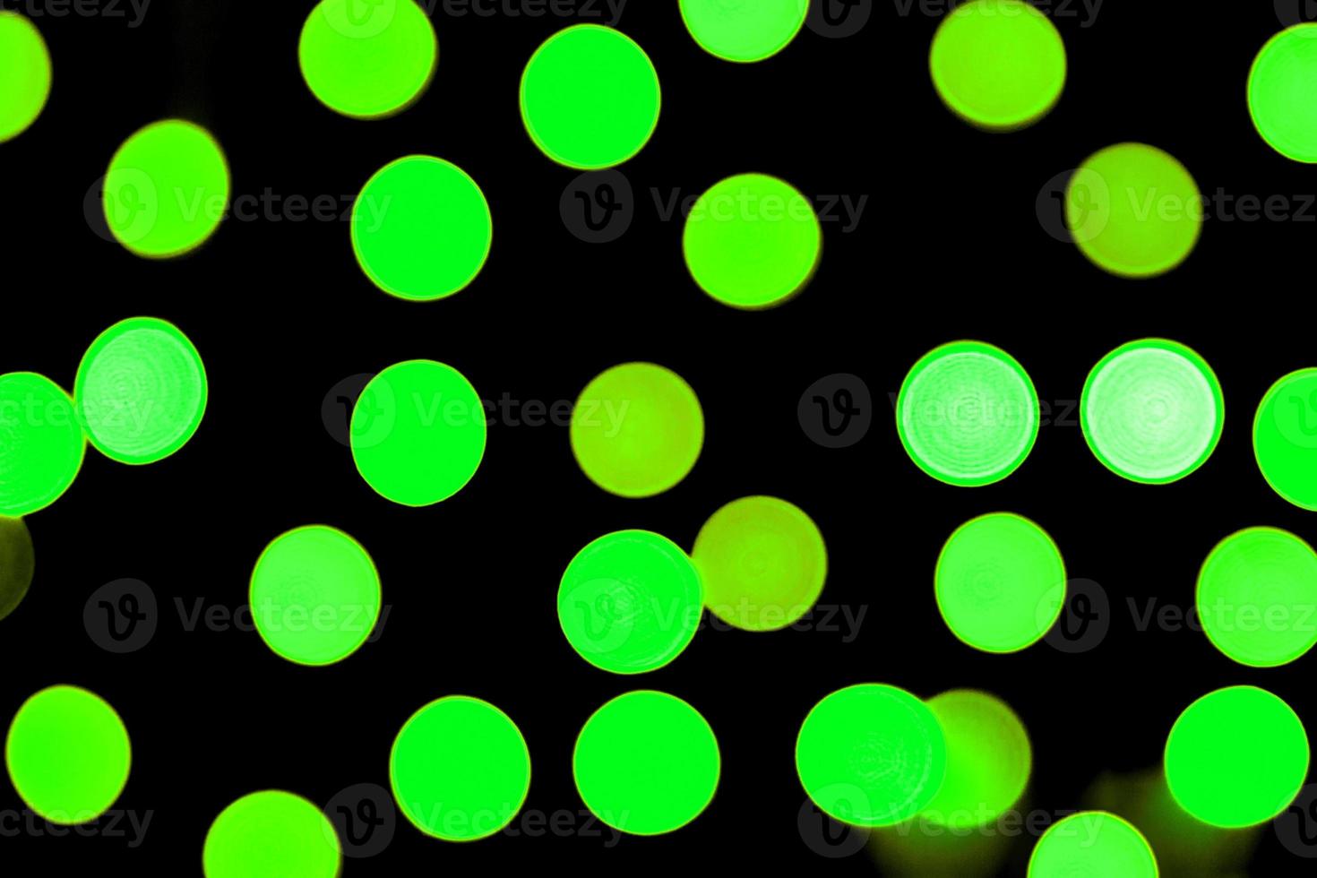 Unfocused abstract colourful bokeh black background. defocused and blurred many round green light photo