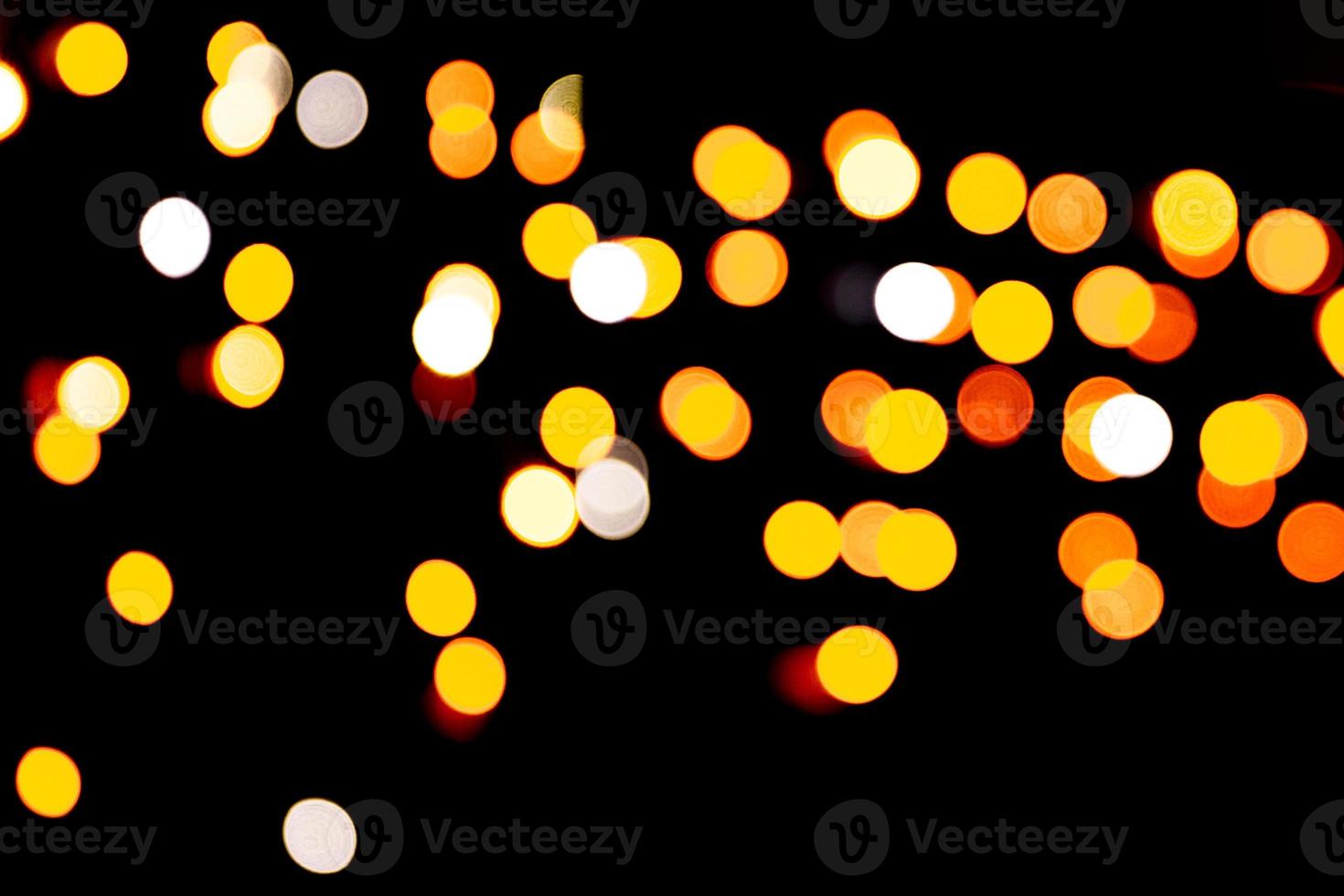 Gold abstract bokeh background. defocused and blurred many round yellow light on dark background photo