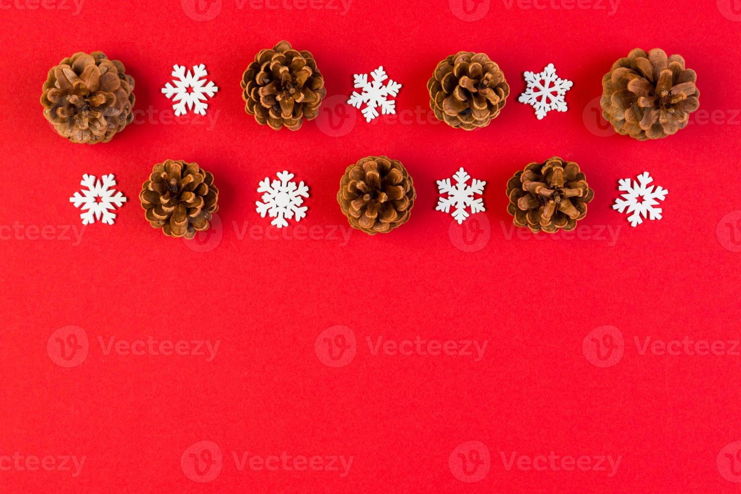 Top view of New Year ornament made of white snowflakes and pine cones on colorful background. Winter holiday concept with empty space for your design photo