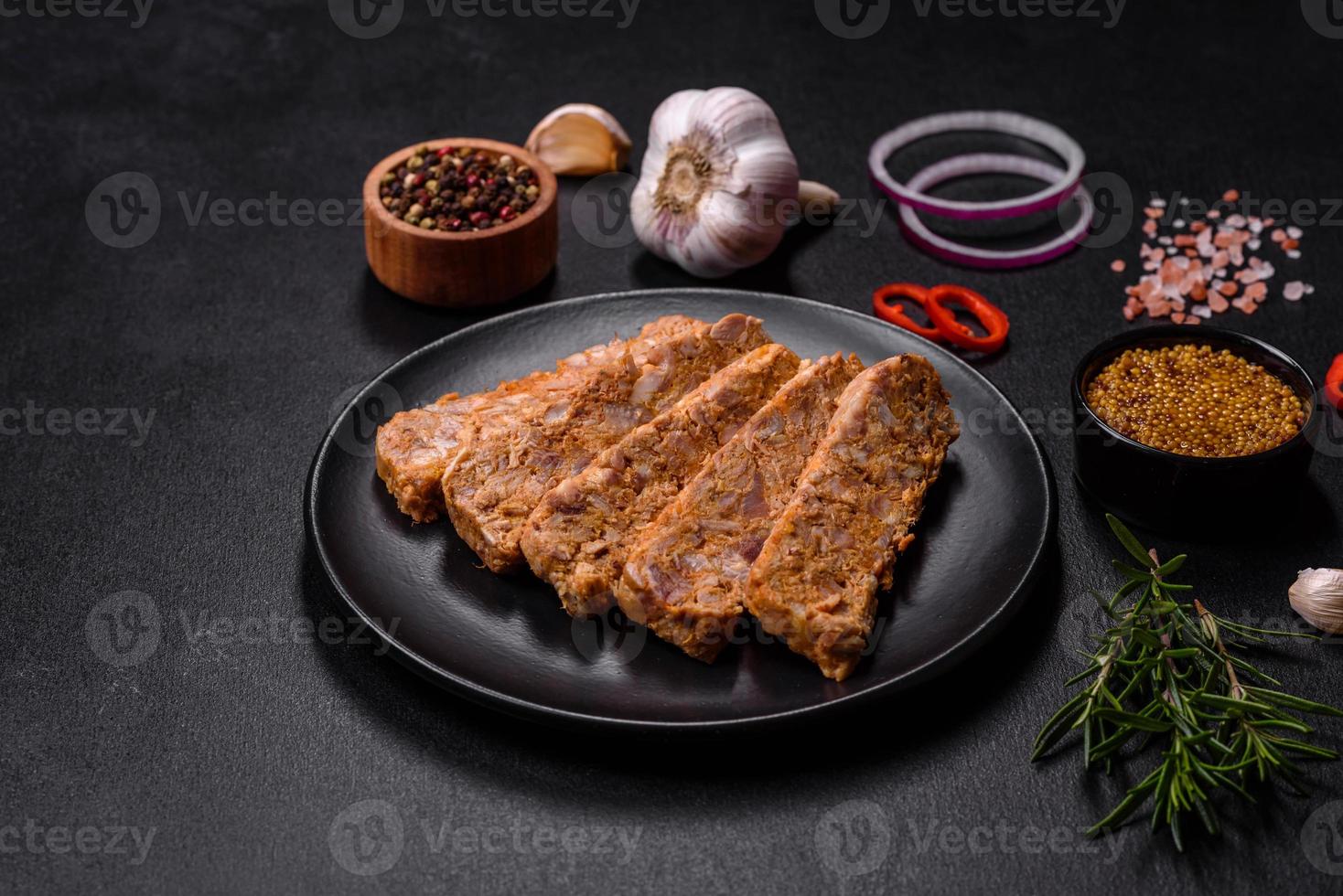 Tasty meat brawn or roll on a wooden cutting board with spices and herbs photo