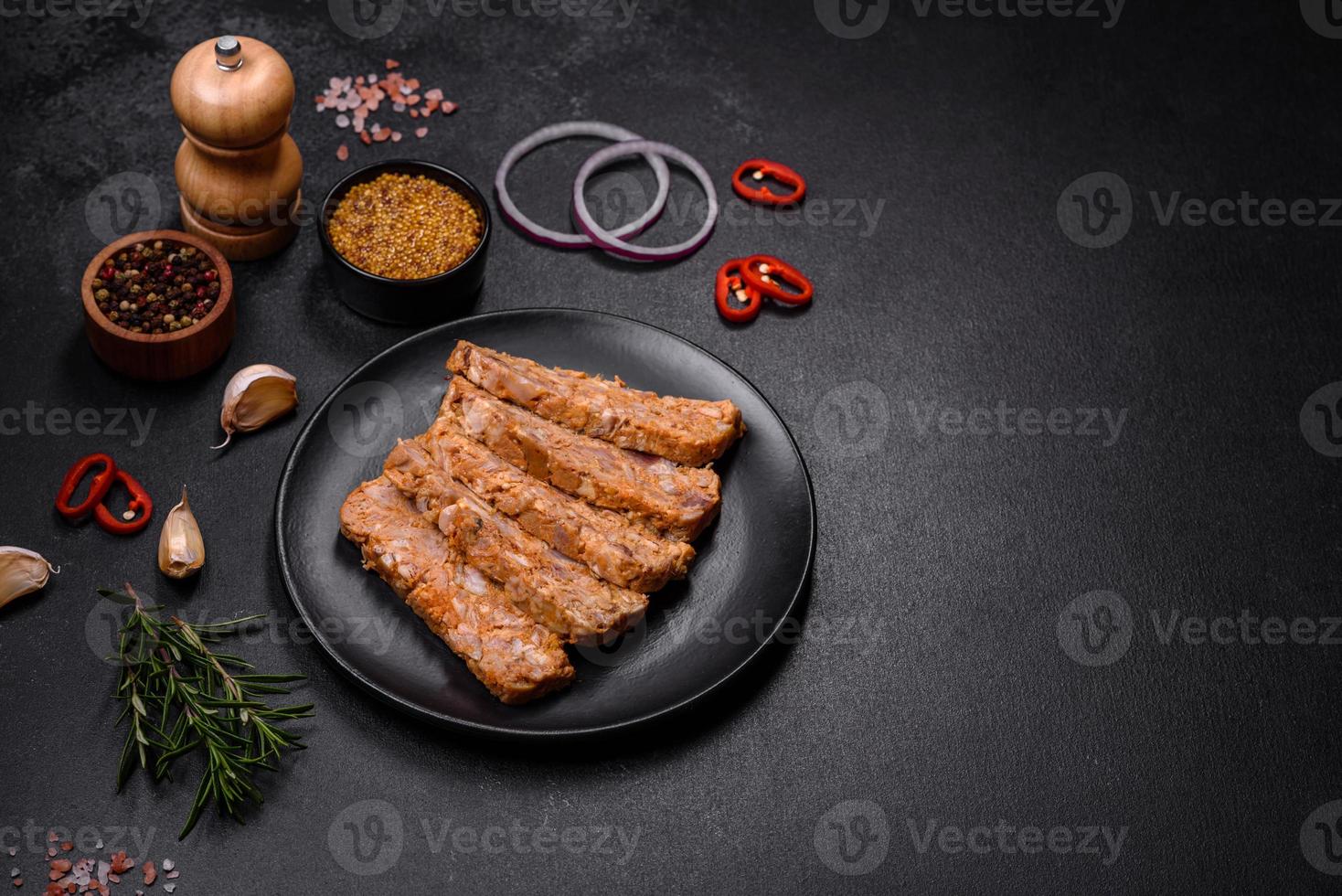Tasty meat brawn or roll on a wooden cutting board with spices and herbs photo