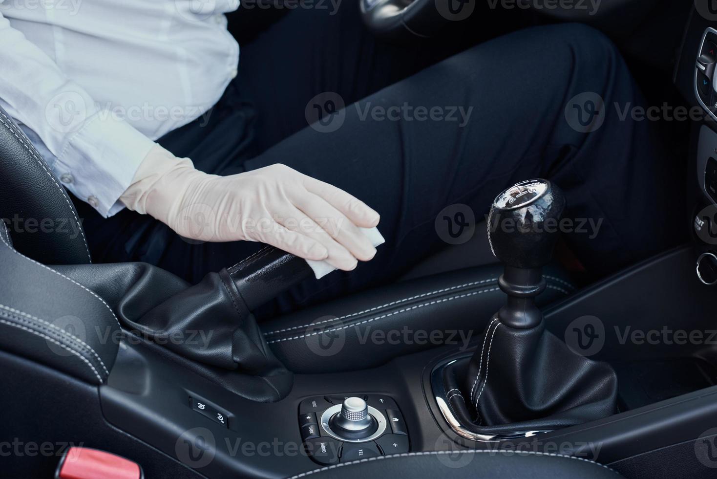 Woman cleaning car interior. Hand with an antibacterial wipe disinfect car photo