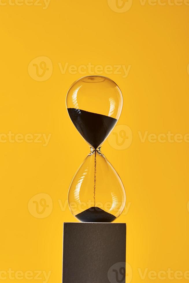 Hourglass on the yellow background with copy space photo