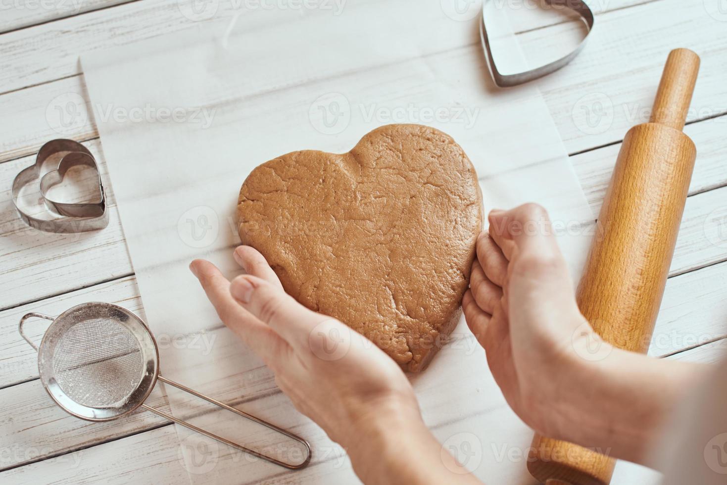 Woman kneads dough with hands in the kitchen photo