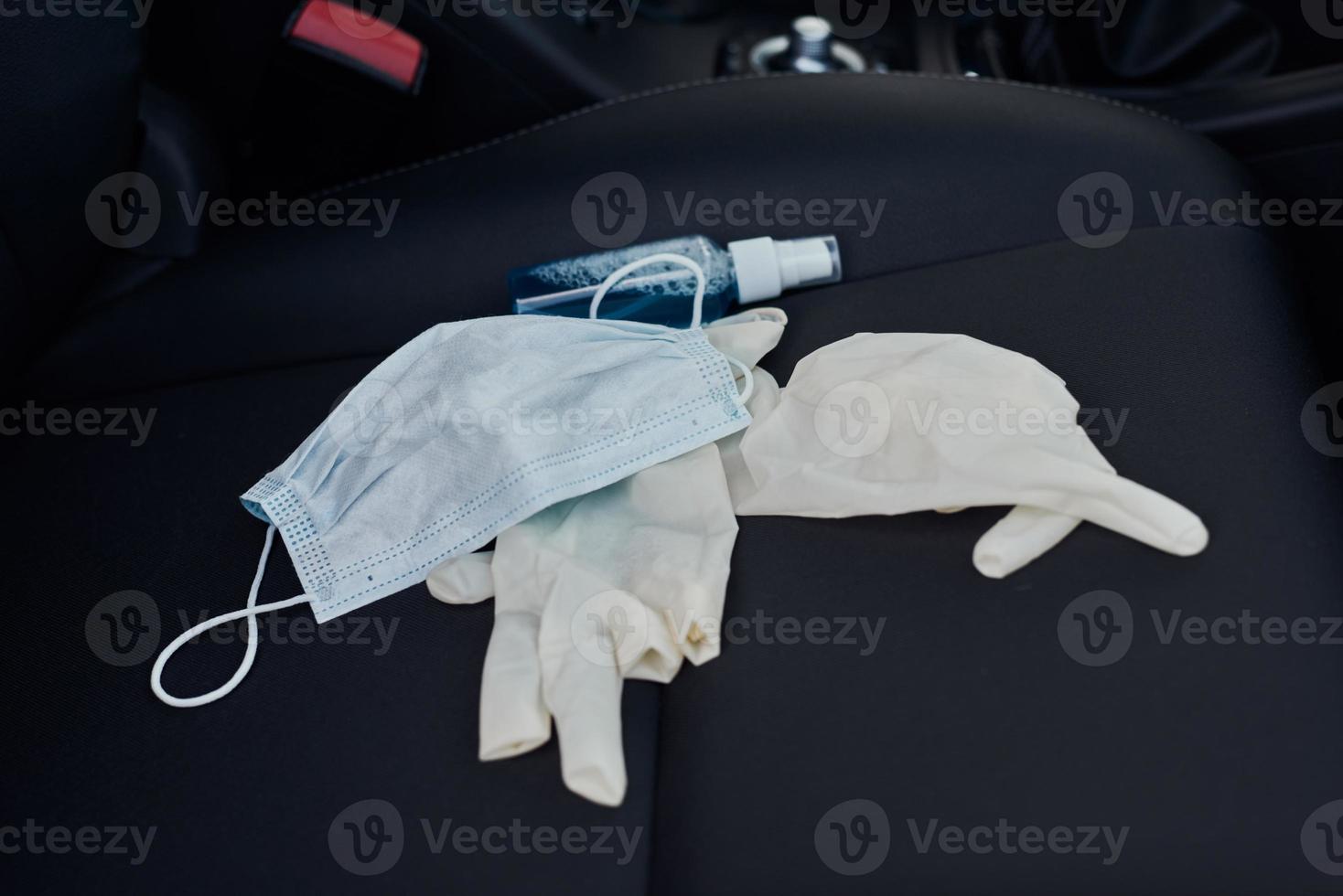 Protective mask medical gloves and antibacterial sanitizer on the car seat photo