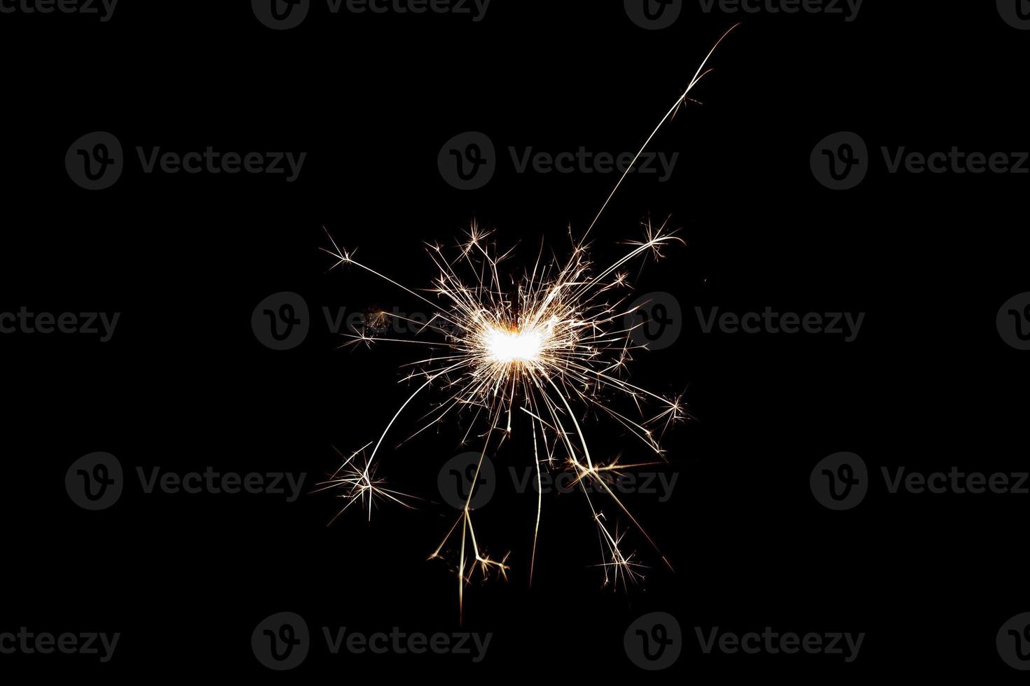 Burning sparkler isolated on black background. Fireworks theme. Light effect and texture. photo