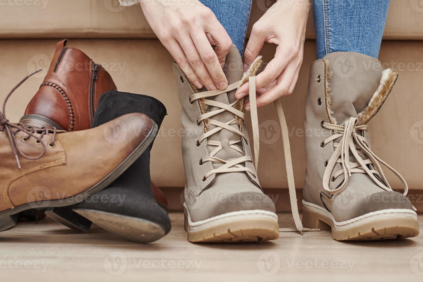 Woman chooses comfortable shoes among a bunch of different pairs photo