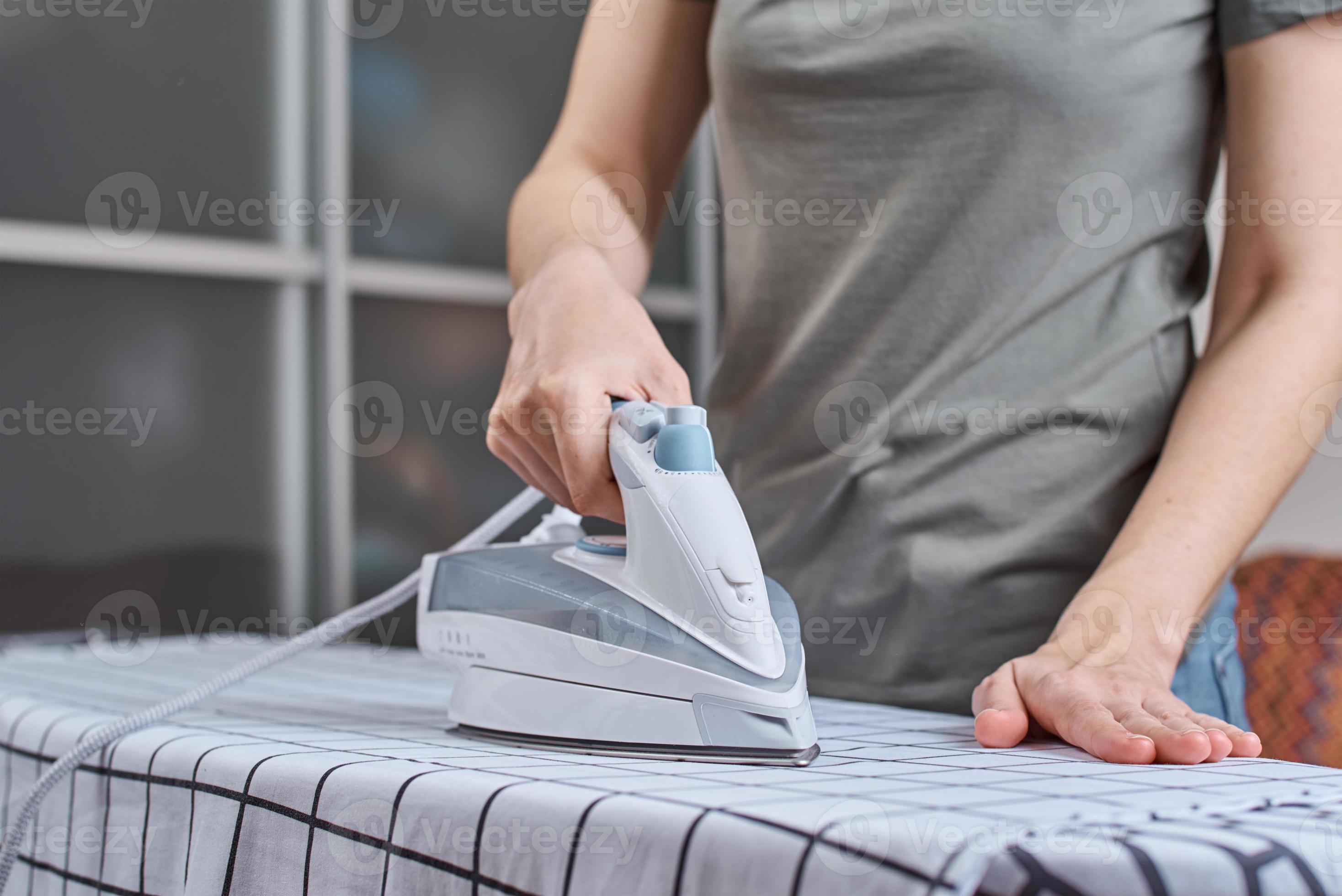 Woman ironing clothes on the ironing board with modern iron 14264430