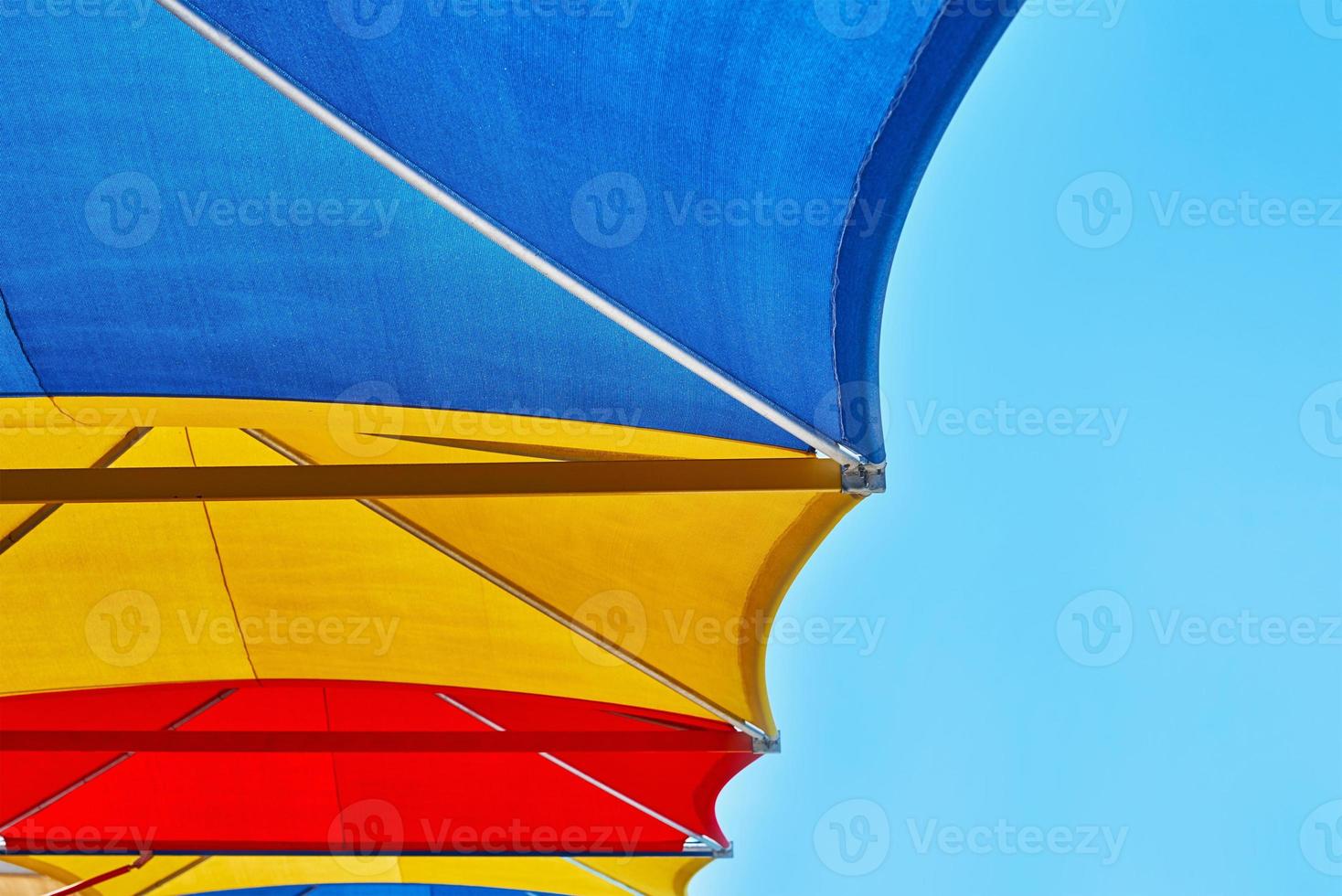 Colored beach umbrellas against blue sky in the summer day photo