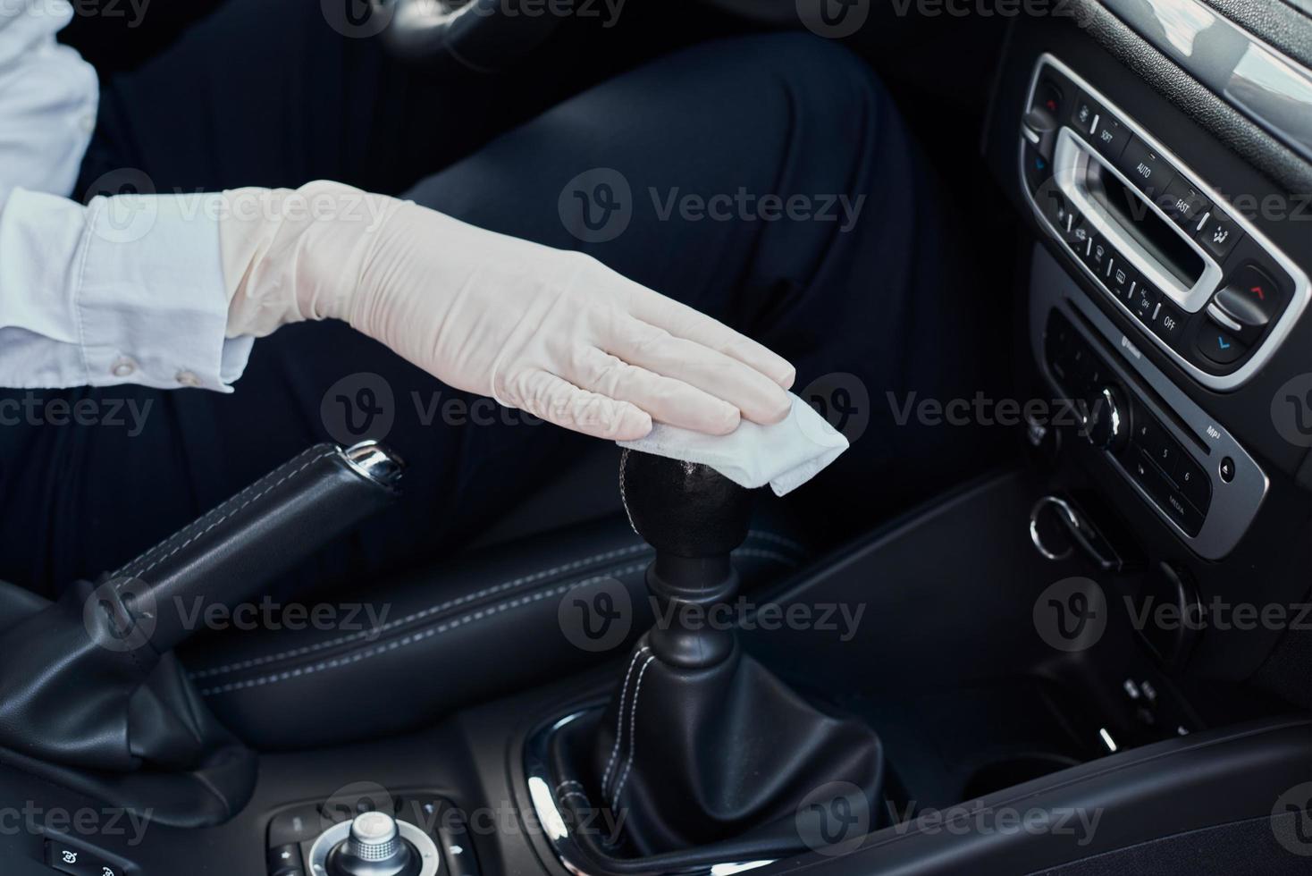 Woman cleaning car interior. Hand with an antibacterial wipe disinfect car photo