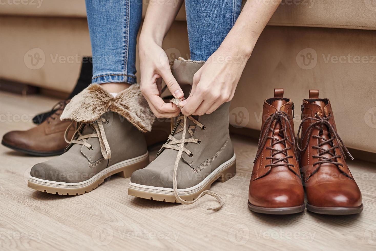 Woman chooses comfortable shoes among a bunch of different pairs photo