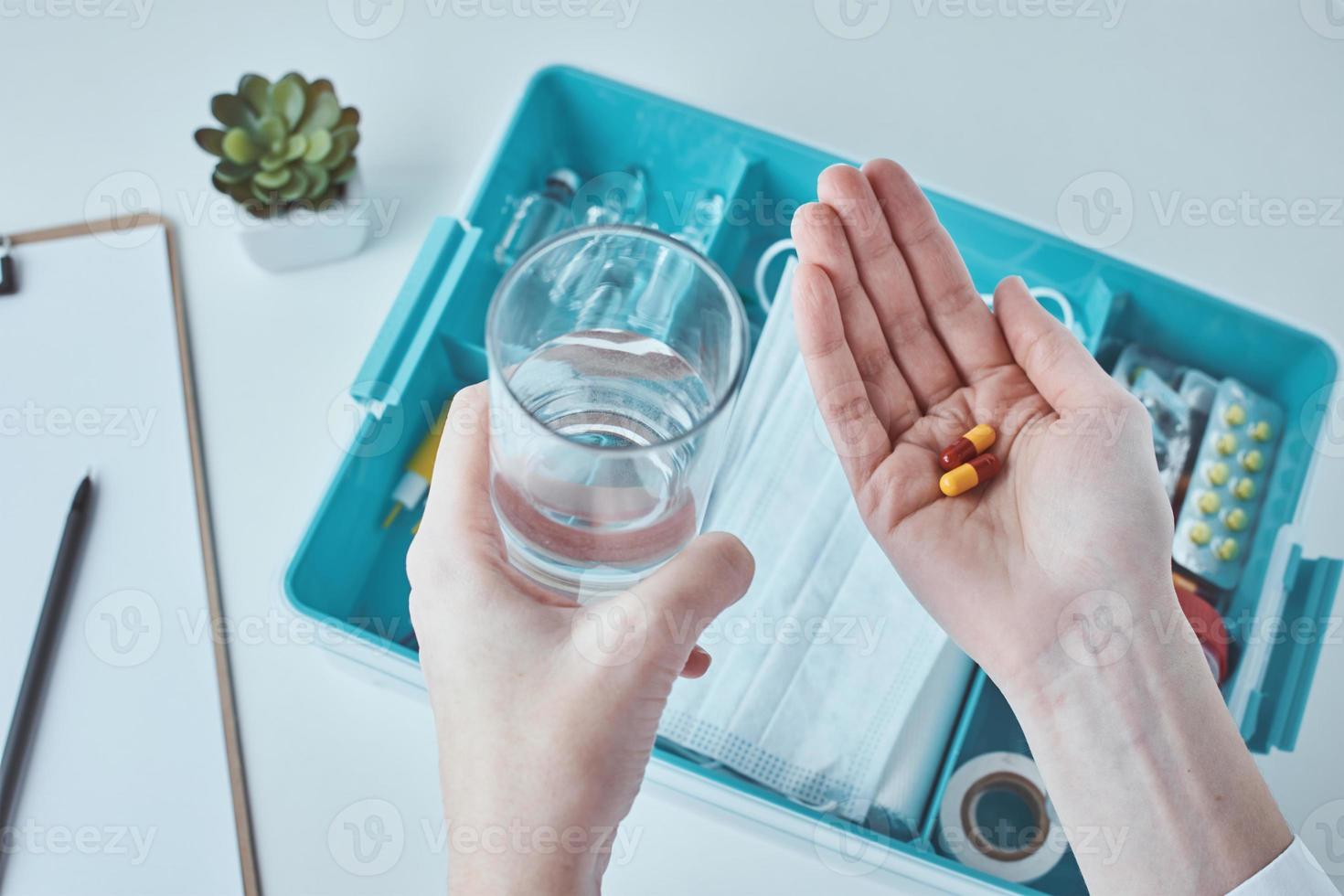 Medical pills in the hand and glass of water. Healthcare and medicine concept photo