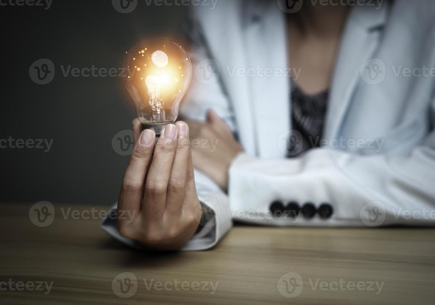 Businesswoman holding a light bulb, Creative new idea. Innovation, brainstorming, solution and inspiration concepts. imagination, creative thinking problem solving. photo