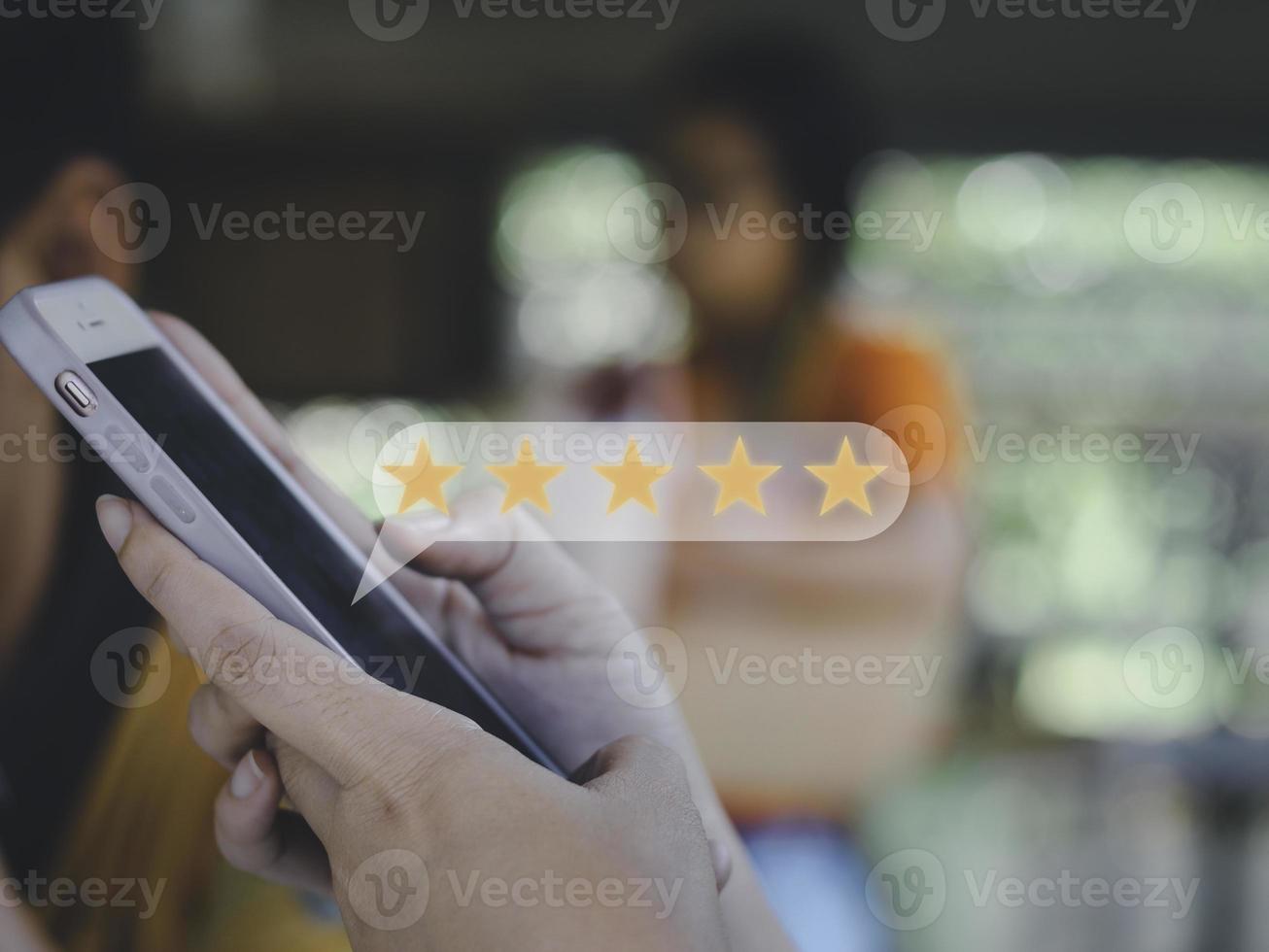 Businesswomen press by hand smart phone give five star symbol of product and service concept, Customer service experience ,increase ,rating and business satisfaction survey. photo