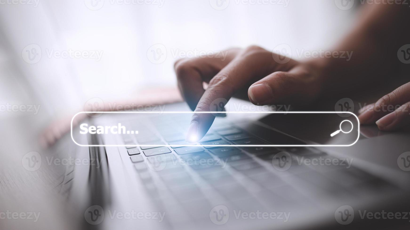 People hand using laptop or computor searching for information in internet online society web with search box icon and copyspace. photo