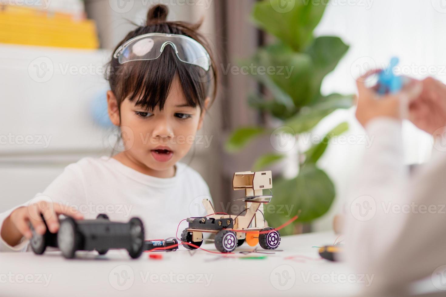 Asia students learn at home in coding robot cars and electronic board cables in STEM, STEAM, mathematics engineering science technology computer code in robotics for kids concept. photo