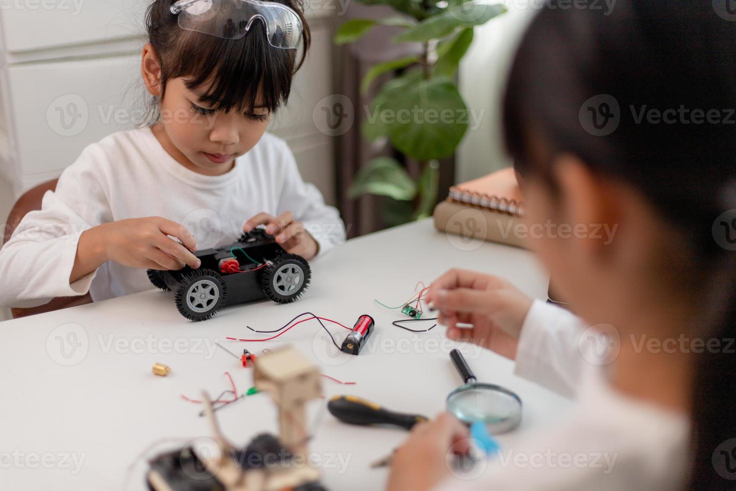 los estudiantes de asia aprenden en casa a codificar autos robot y cables de tableros electrónicos en tallo, vapor, ingeniería matemática, ciencia, tecnología, código de computadora en robótica para el concepto de niños. foto