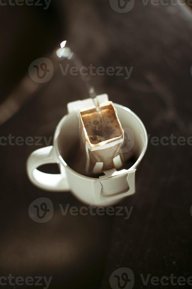 The process of brewing coffee. Water is poured into a drip coffee bag in a mug. Trends in brewing coffee at home photo