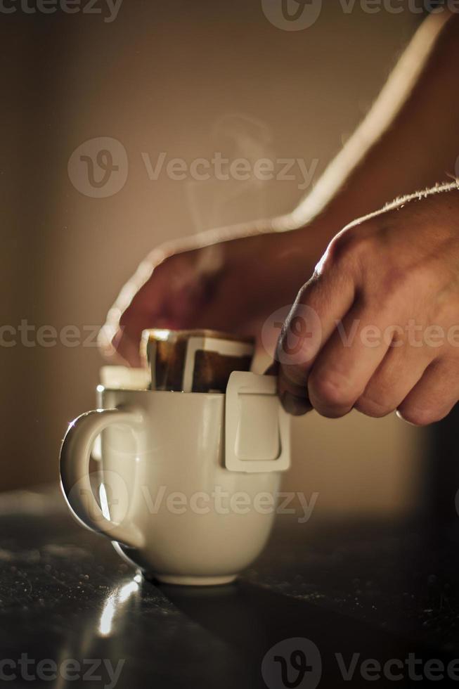 The process of brewing coffee. Water is poured into a drip coffee bag in a mug. Trends in brewing coffee at home photo