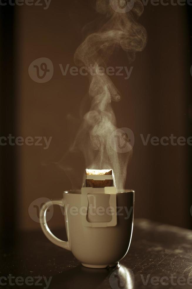 The process of brewing coffee. Water is poured into a drip coffee bag in a mug. Trends in brewing coffee at home photo