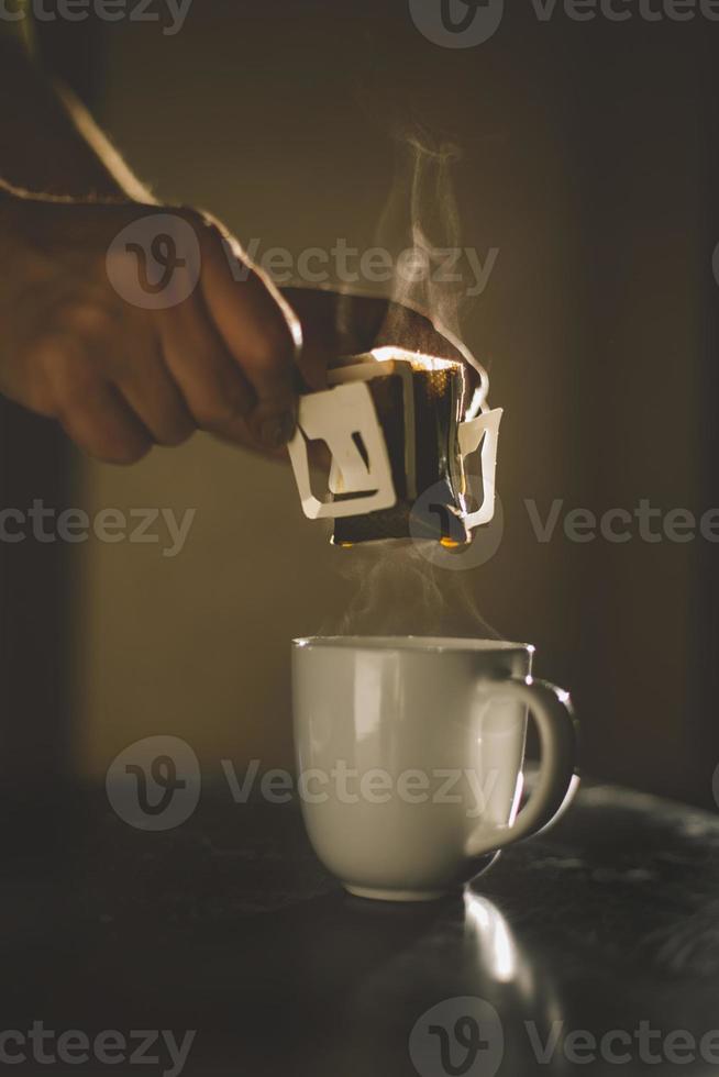 The process of brewing coffee. Water is poured into a drip coffee bag in a mug. Trends in brewing coffee at home photo