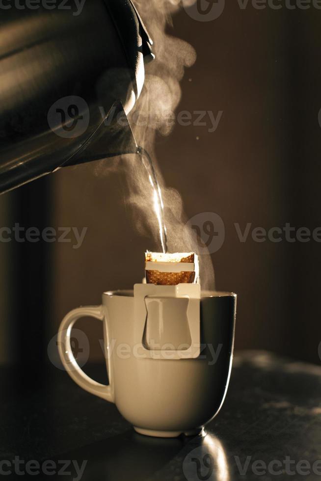 The process of brewing coffee. Water is poured into a drip coffee bag in a mug. Trends in brewing coffee at home photo