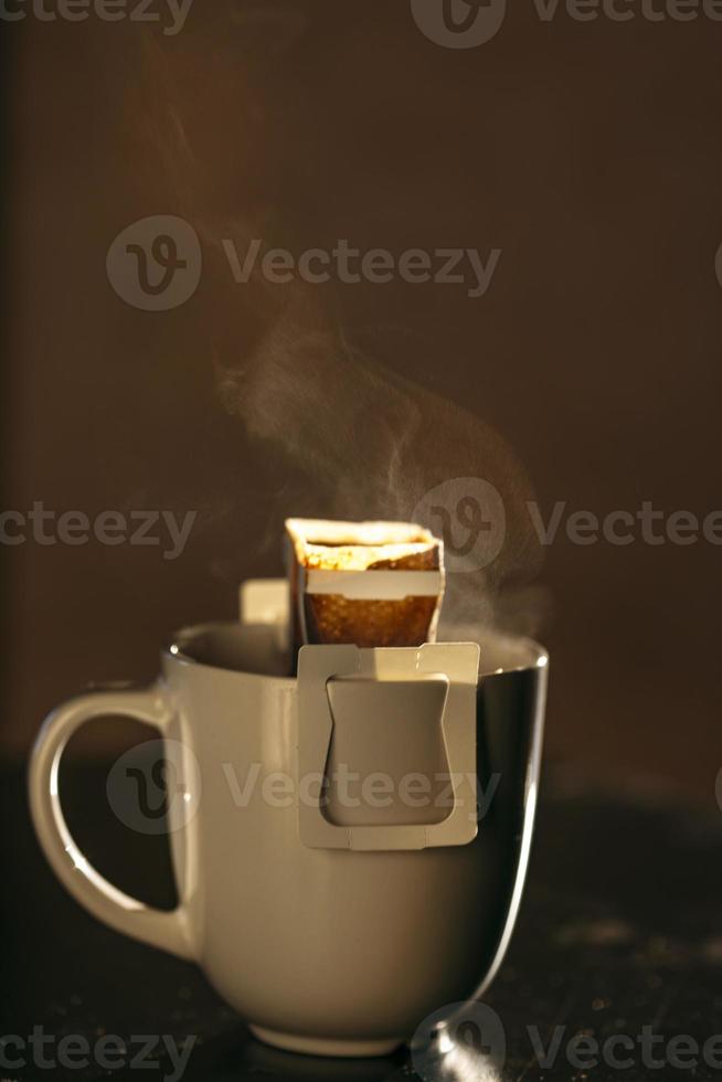 The process of brewing coffee. Water is poured into a drip coffee bag in a mug. Trends in brewing coffee at home photo