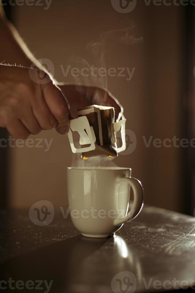 The process of brewing coffee. Water is poured into a drip coffee bag in a mug. Trends in brewing coffee at home photo