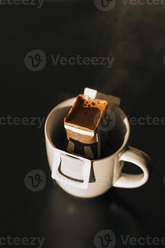 The process of brewing coffee. Water is poured into a drip coffee bag in a mug. Trends in brewing coffee at home photo